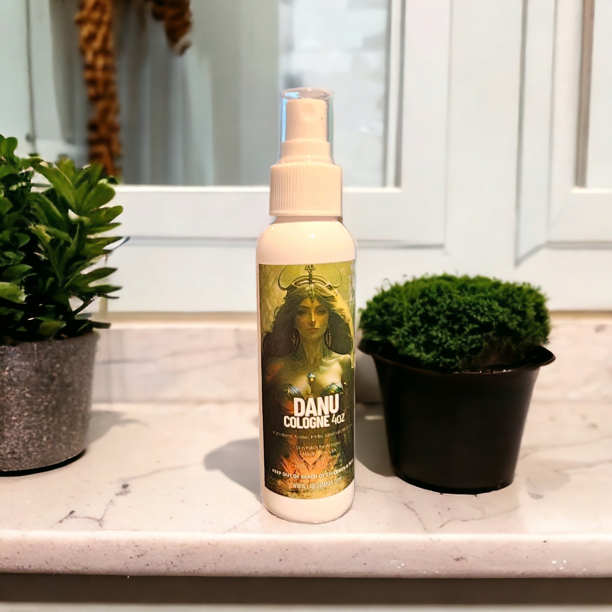 Image of green-tinted LAB Danu Cologne bottle with a glass water drop charm. The bottle rests amidst lush foliage, symbolizing connection to earth and Danu, the Celtic Mother Goddess, radiating tranquility and spiritual renewal. labshaman, goddess