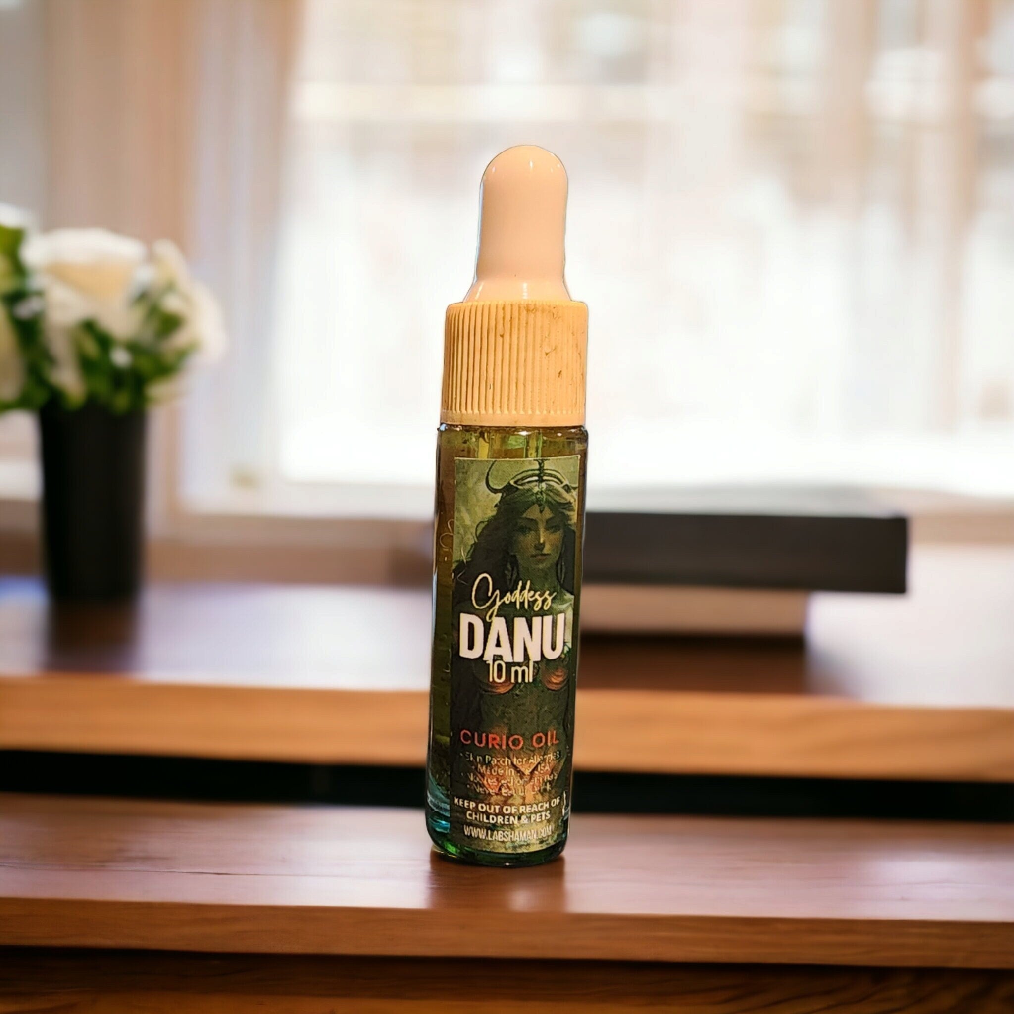 LAB Shaman&#39;s Danu Oil, encased in a glass vial, symbolizes fertility and abundance. With a clear green quartz, the oil reflects the essence of Danu, the Celtic Mother Goddess.